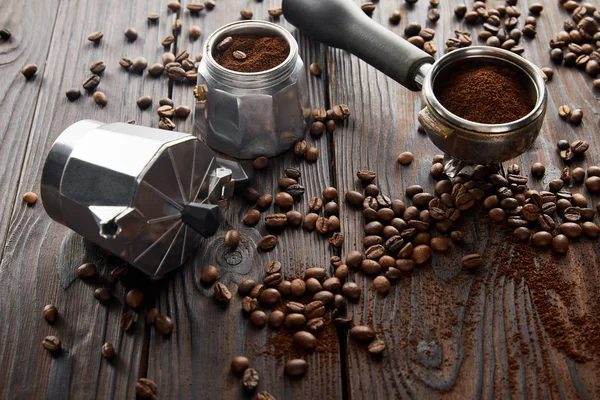 Geyser cafeteira perto portafilter na superfície de madeira com grãos de café — Fotografia de Stock