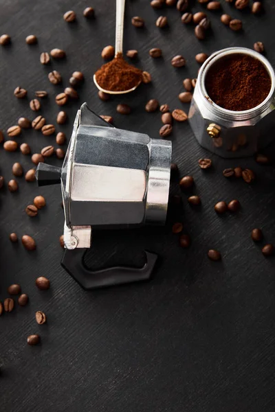 Pièces séparées de la cafetière geyser près de la cuillère sur une surface en bois sombre avec des grains de café — Photo de stock