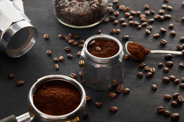 Parti di caffettiera geyser vicino cucchiaio con caffè e portafiltro su superficie di legno scuro con chicchi di caffè — Foto stock