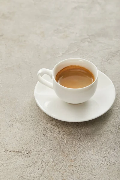 Weiße Tasse mit Kaffee auf Untertasse auf heller Marmoroberfläche — Stockfoto