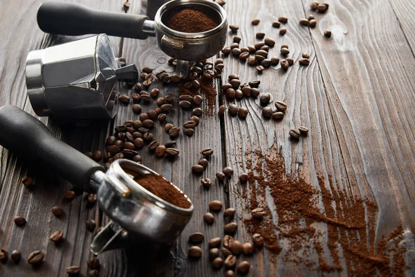 Geysir-Kaffeemaschine zwischen Portafiltern auf dunkelbrauner Holzoberfläche mit Kaffeebohnen — Stockfoto