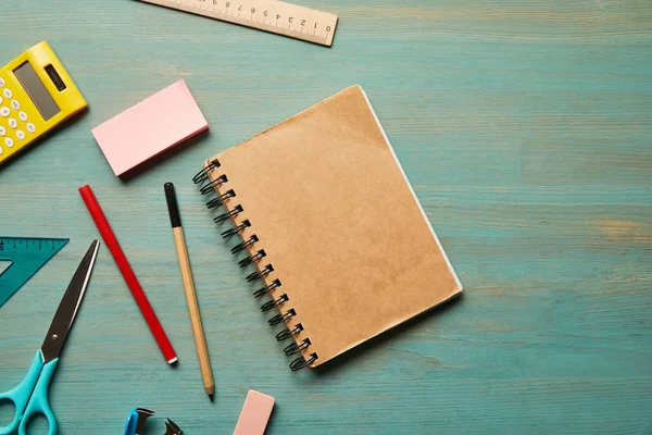 Top view of empty notebook near school supplies at wooden table — Stock Photo