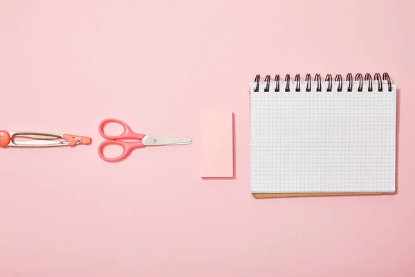 Apartamento leigos com material escolar perto de caderno em branco isolado em rosa — Fotografia de Stock