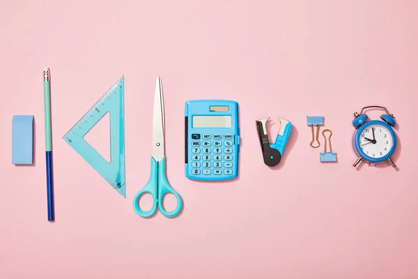 Flat lay com material escolar azul isolado em rosa — Fotografia de Stock