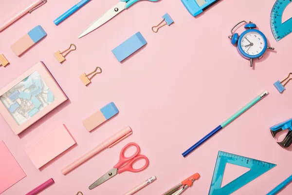 Flat lay with blue school supplies and copy space isolated on pink — Stock Photo