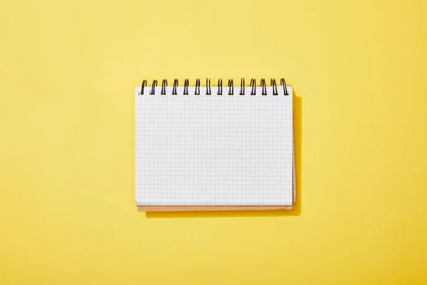 Top view of blank white notebook on yellow background — Stock Photo