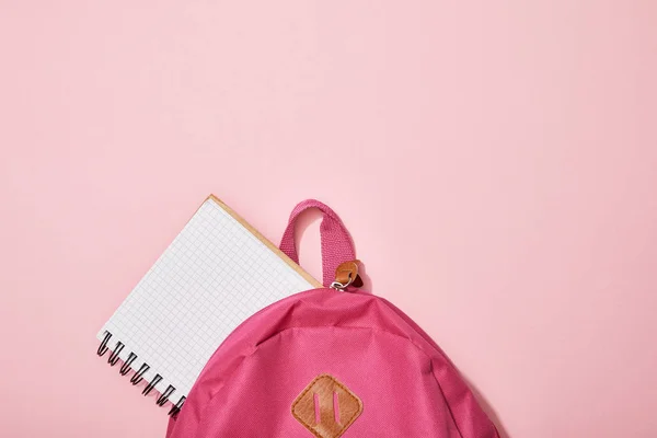 Vista superior del cuaderno en blanco cerca de la mochila aislada en rosa — Stock Photo