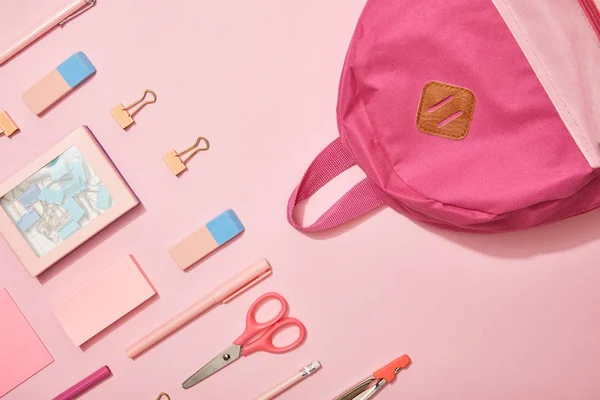 Flat lay com material escolar rosa e mochila isolada em rosa — Fotografia de Stock