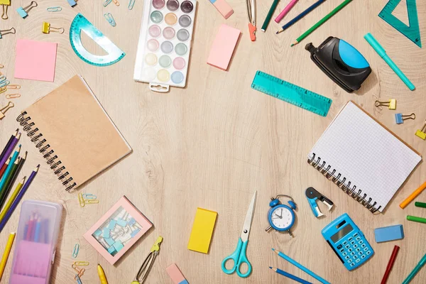 Vue de dessus de diverses fournitures scolaires sur un bureau en bois — Photo de stock