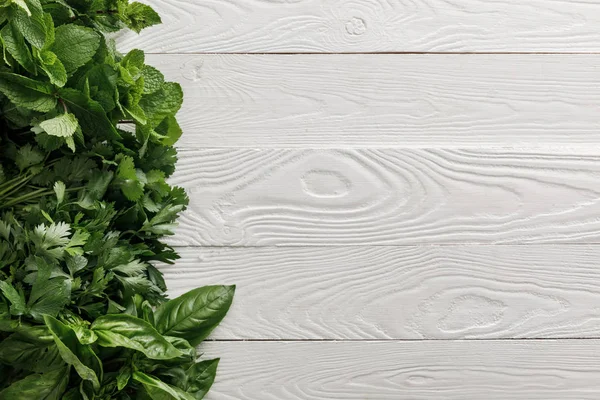 Top view of basil, cilantro, parsley and peppermint bundles on white white wooden surface — Stock Photo