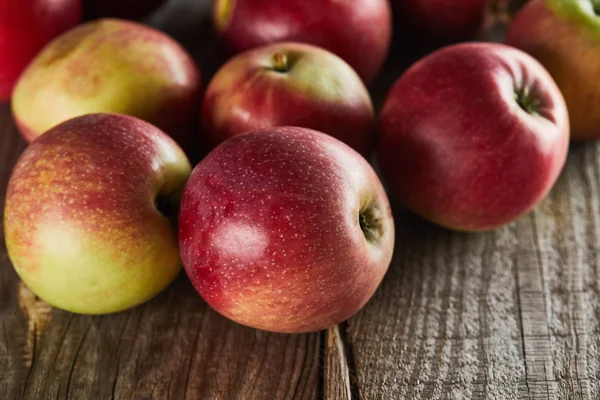 Ripe juicy apples on brown wooden surface — Stock Photo