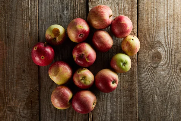 Top view of ripe juicy apples on brown wooden surface — Stock Photo