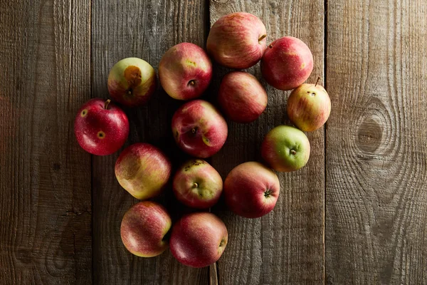 Vista superior de manzanas rojas maduras en la superficie de madera marrón - foto de stock