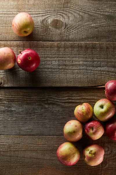 Top view of ripe apples on brown wooden surface with copy space — Stock Photo