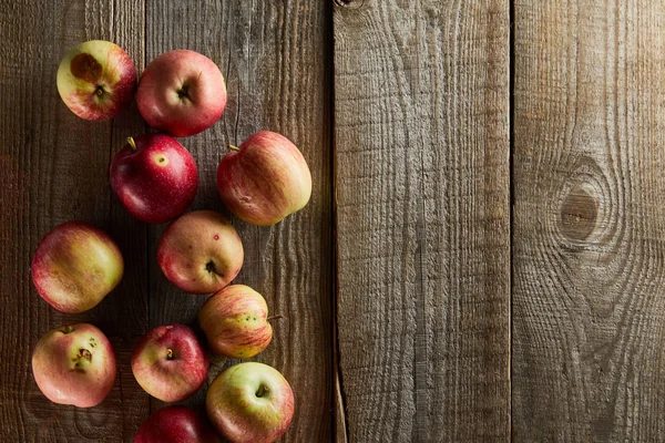 Top view of red apples on brown wooden surface with copy space — Stock Photo