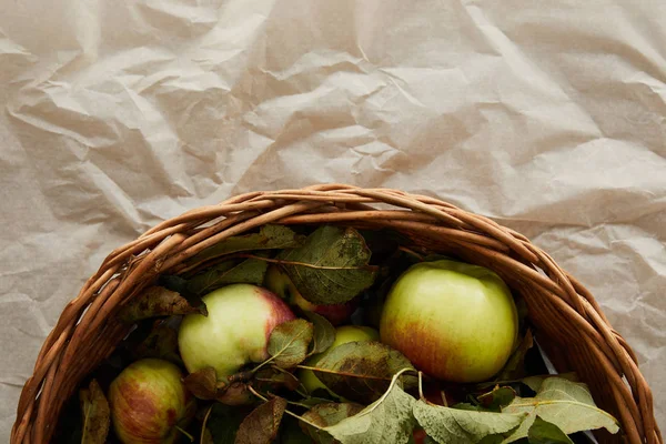 Top view of basket with apples on parchment paper with copy space — Stock Photo