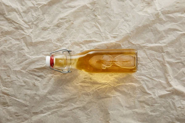 Top view of bottle of apple cider on parchment paper with copy space — Stock Photo