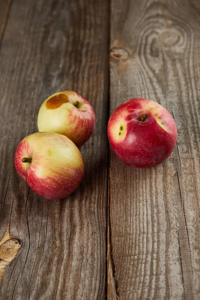 Agriculteurs pommes avec petite tache pourrie sur la surface en bois brun avec espace de copie — Photo de stock