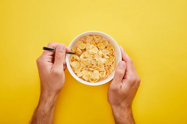 Abgeschnittene Ansicht des Mannes mit Schale mit Cornflakes isoliert auf gelb — Stockfoto