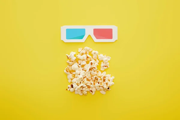 Vista dall'alto di deliziosi popcorn e bicchieri 3d su sfondo giallo — Foto stock
