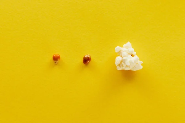Вид зверху смачний попкорн і кукурудза на жовтому фоні — стокове фото