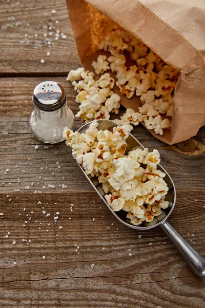 Blick von oben auf salziges Popcorn verstreut auf Holzgrund — Stockfoto