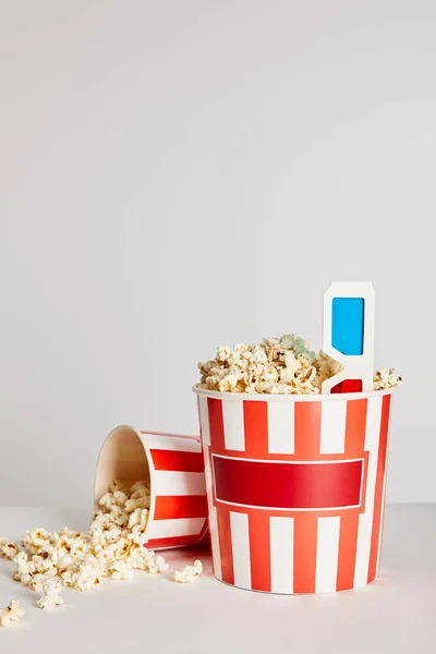 Leckeres frisches Popcorn in Eimern mit 3D-Gläsern isoliert auf grau — Stockfoto