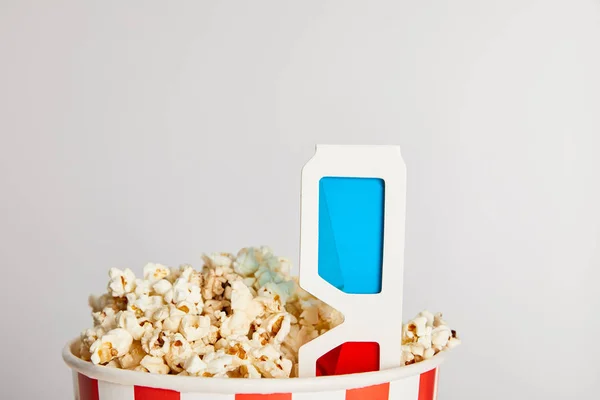 Tasty fresh popcorn in paper bucket with 3d glasses isolated on grey — Stock Photo