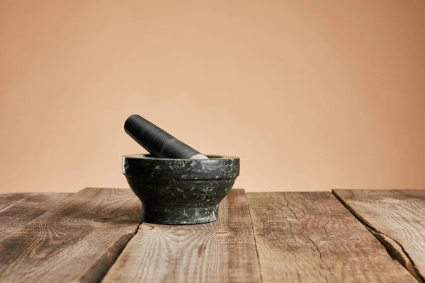 Argamassa de pedra cinza na mesa de madeira isolada em marrom — Fotografia de Stock