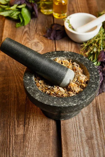 Mortars with pestles with herbal mix on wooden surface — Stock Photo