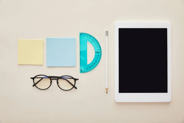 Vue du haut des notes collantes près des lunettes et de la tablette numérique avec écran vierge isolé sur beige — Photo de stock