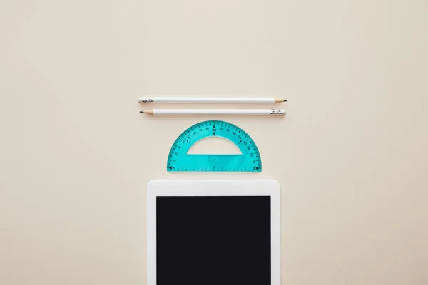 Top view of pencils and ruler near digital tablet with blank screen isolated on beige — Stock Photo