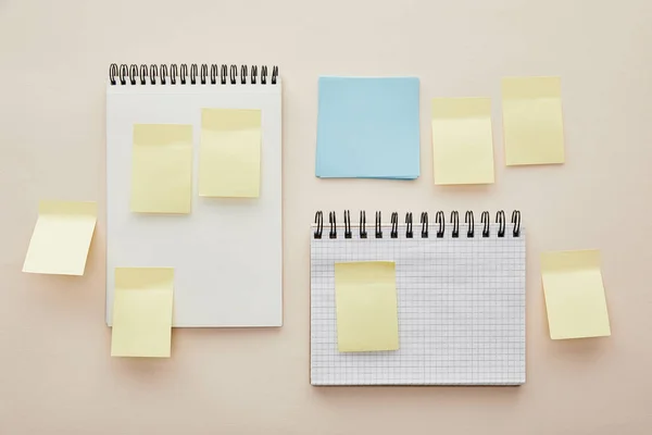 Top view of blank sticky notes on notebooks isolated on beige — Stock Photo