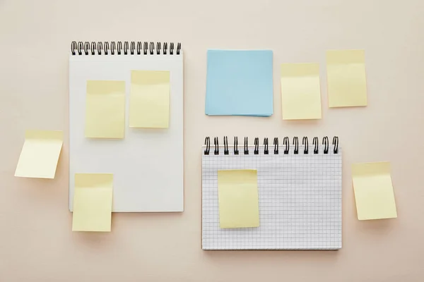 Vue du haut des notes autocollantes vierges sur les carnets isolés sur beige — Photo de stock