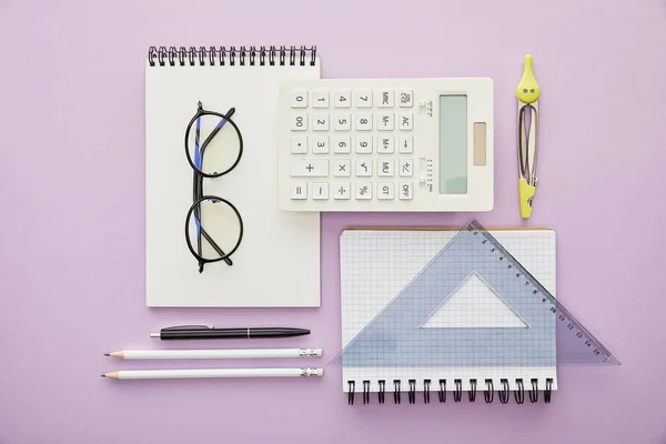 Couché plat avec des règles et une calculatrice près des ordinateurs portables et de la papeterie isolés sur violet — Photo de stock