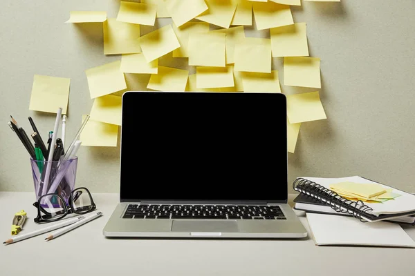 Laptop with blank screen near empty sticky notes and stationery on grey and white — Stock Photo