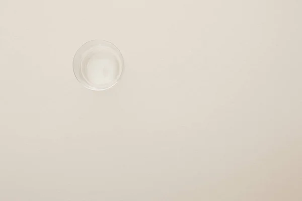 Vue de dessus du verre avec de l'eau isolée sur beige — Photo de stock