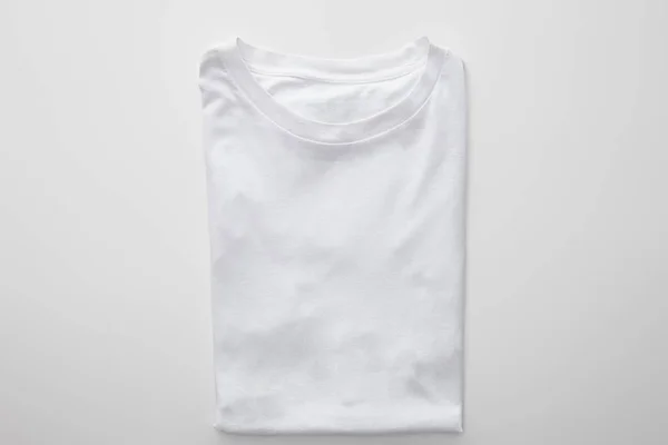 Верхний вид пустой клетчатой сложенной футболки на белом фоне — стоковое фото