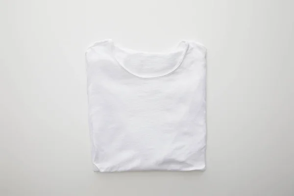 Vue du dessus du t-shirt plié à carreaux sur fond blanc — Photo de stock