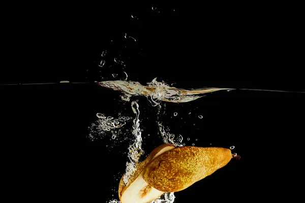 Ripe pear halves falling deep in water with splash isolated on black — Stock Photo