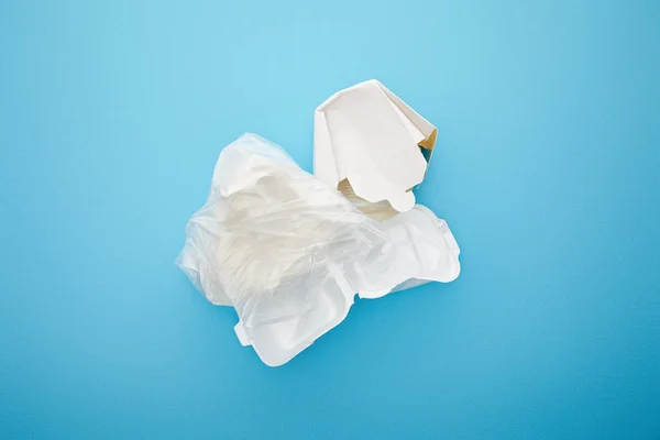 Top view of plastic bag with disposable containers on blue background — Stock Photo