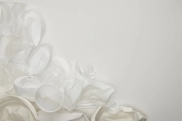 Top view of crumpled plastic cups and plates white background with copy space — Stock Photo