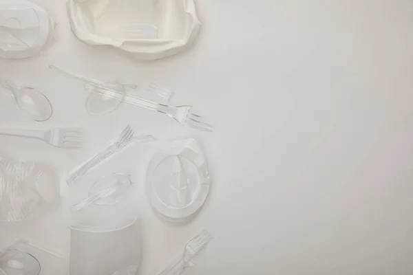 Top view of crumpled disposable cups and plate on white background with copy space — Stock Photo