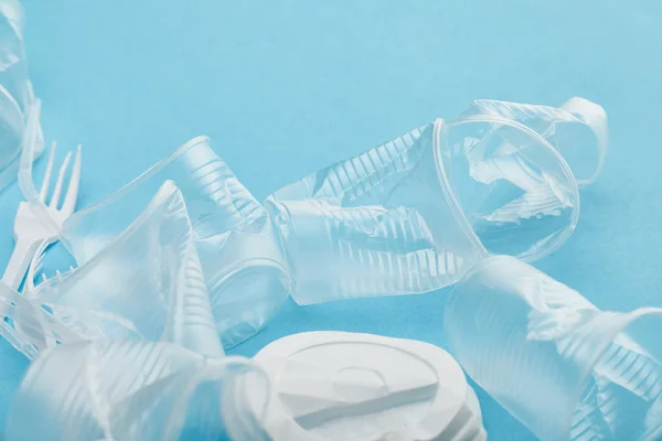 Copos de plástico transparente amassado no fundo azul — Fotografia de Stock