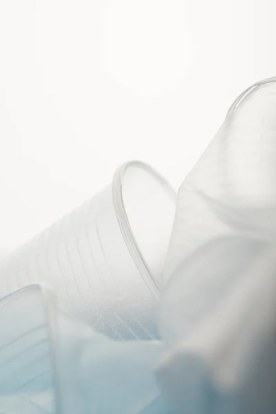 Close up view of crumpled transparent disposable cups on white background — Stock Photo