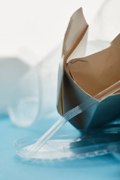 Close up view of crumpled cardboard container on blue background — Stock Photo