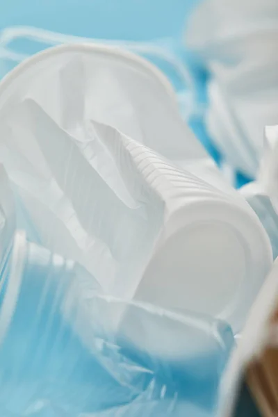 Vue rapprochée des déchets plastiques froissés sur fond bleu — Photo de stock