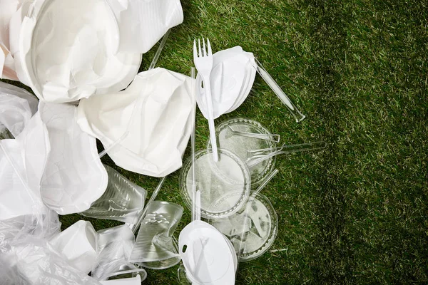 Draufsicht auf zerknüllten Plastik- und Pappmüll im Gras — Stockfoto