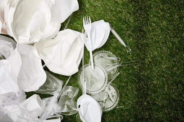 Vue du dessus des déchets en plastique et en carton froissés sur l'herbe — Photo de stock