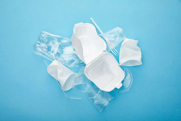 Top view of pile of plastic rubbish on blue background — Stock Photo